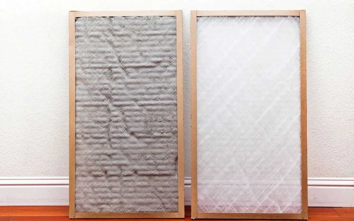 A dirty air filter next to a clean one, leaning against a wall