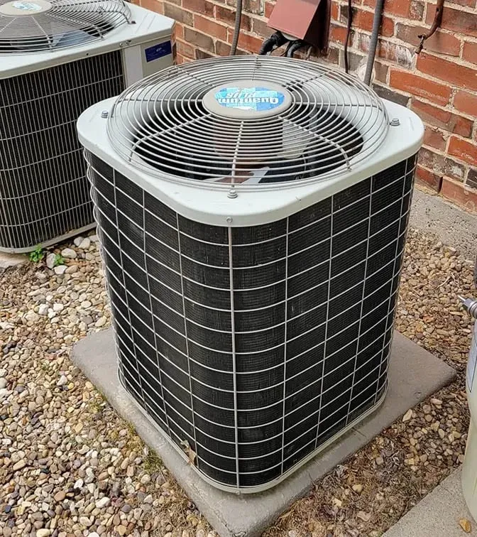 Dual American Standard outdoor AC condenser units on concrete pads beside a brick home in Lewisville TX