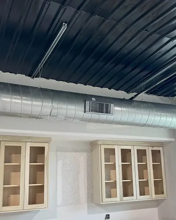 Exposed commercial ductwork in ceiling during professional air duct cleaning service -- Cold Factor HVAC