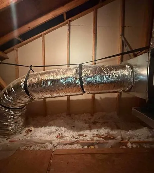 Flexible ductwork connected to an air handler unit in a residential attic -- Cold Factor air duct cleaning and ductwork repair