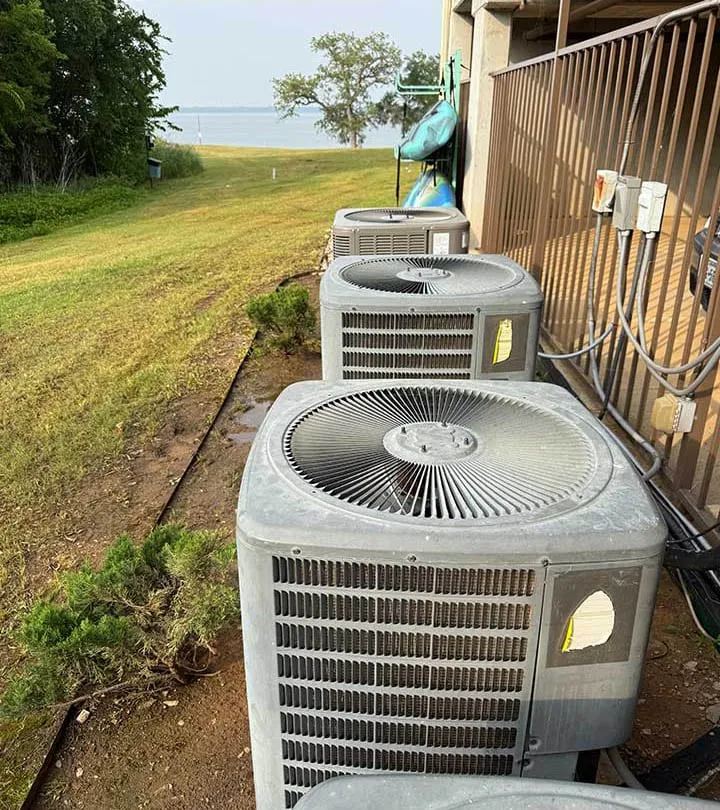 Multiple outdoor AC condenser units installed along a lakeside residential property in Texas -- Cold Factor HVAC