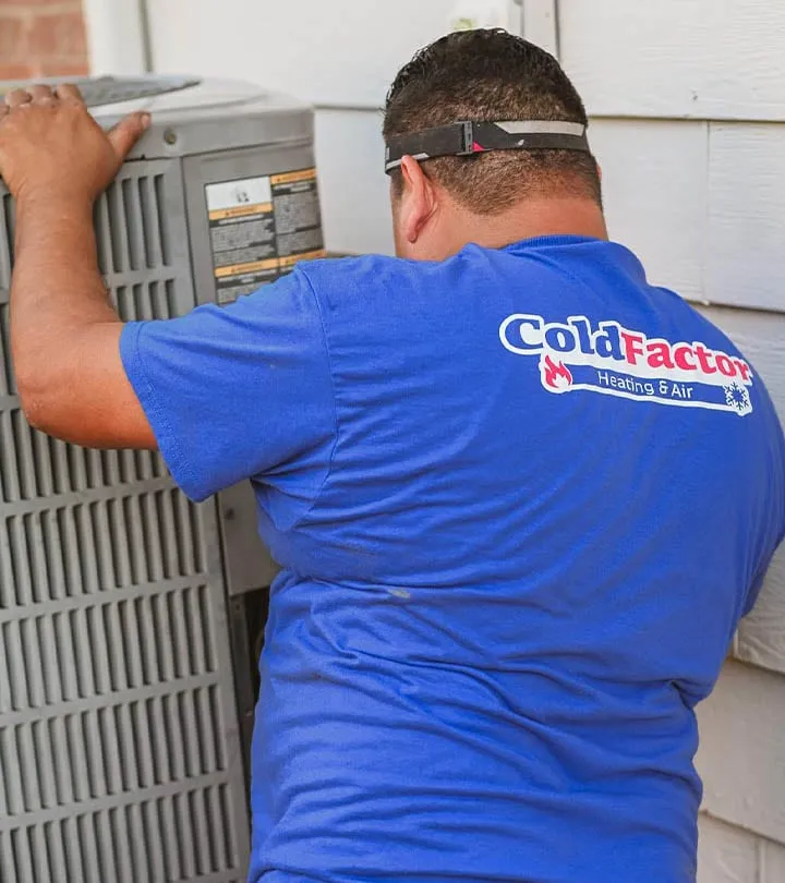 Cold Factor Heating and Air technician inspecting an outdoor AC condenser unit at a residential property in Flower Mound TX
