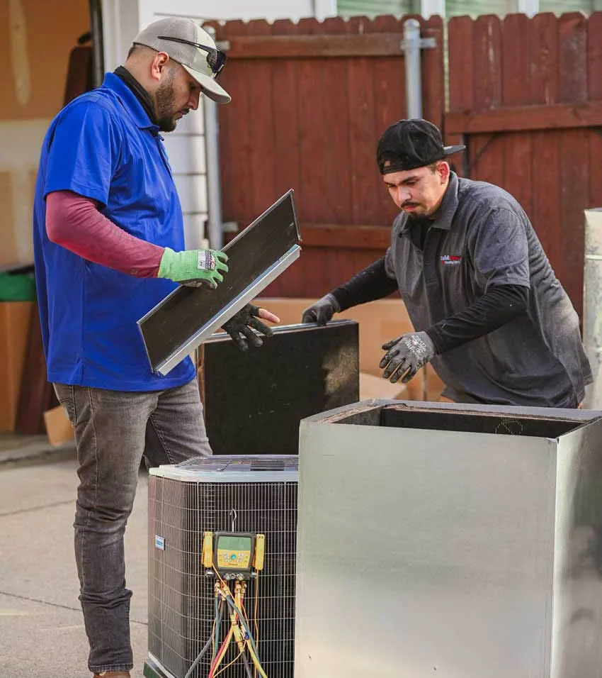 Cold Factor HVAC technicians performing preventative AC maintenance and inspection on outdoor condenser unit