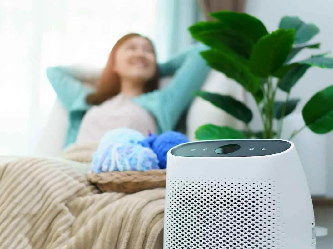 Woman relaxing comfortably at home with a portable air purifier -- Cold Factor indoor air quality services Flower Mound TX