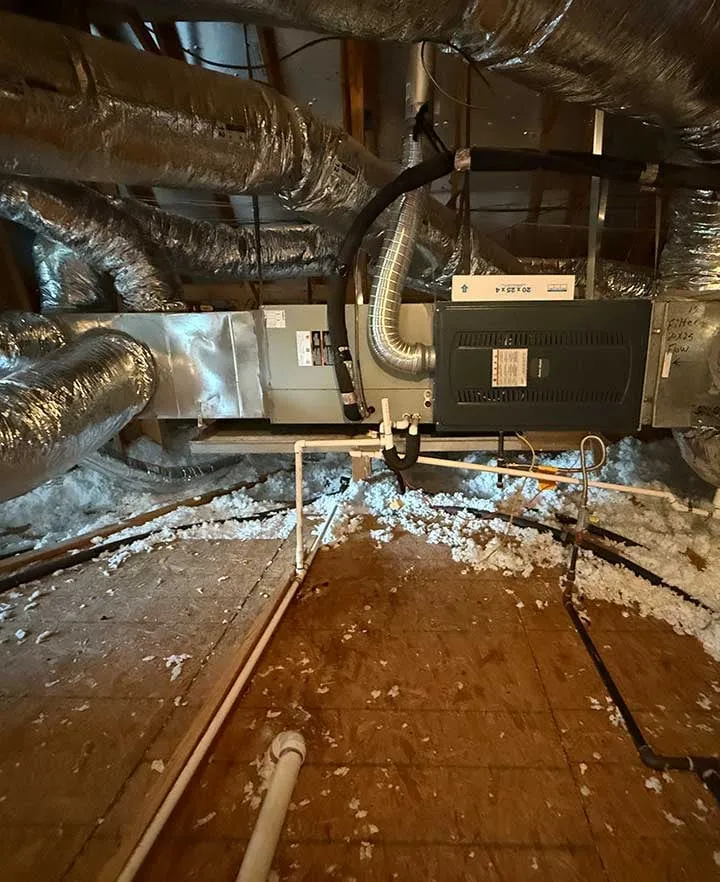 Residential attic HVAC system showing air handler, furnace, and connected ductwork -- Cold Factor heating and air installation