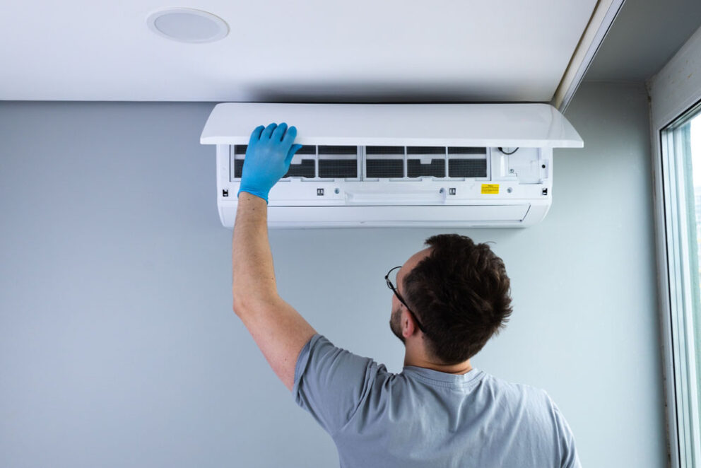 technician inspecting an AC unit’s components